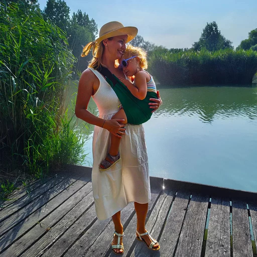 Mother carrying a child by the lake